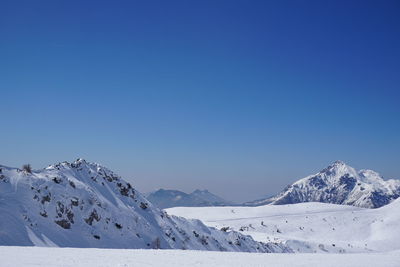 Scenic view of snowcapped mountains against clear blue sky