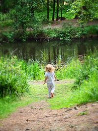 Rear view full length of girl walking on field