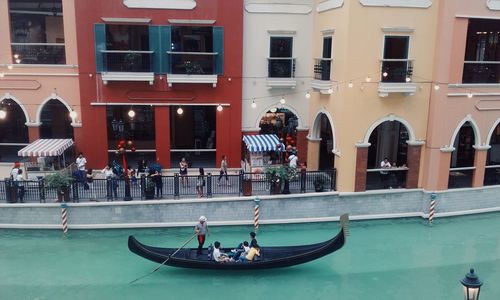 People in boat against buildings