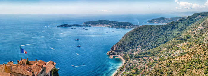 Aerial view of buildings by sea against sky