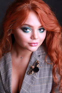 Close-up portrait of sensuous young woman against black background