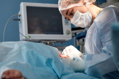 Midsection of doctor examining patient in hospital