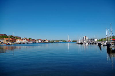 View of marina at harbor against blue sky