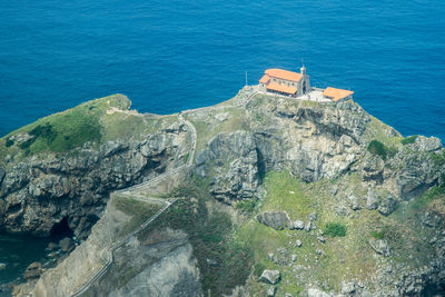 High angle view of rocks by sea against blue sky san juan de gatzelugatxe beautiful place in euskadi