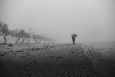 Rear view of man standing on snow covered land