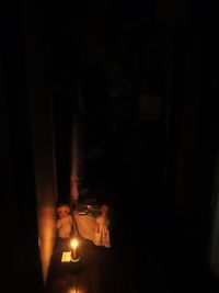 Close-up of lit candle in darkroom