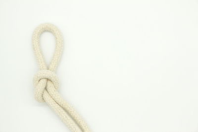 Close-up of rope tied on white background