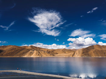 Scenic view of lake and mountains against blue sky