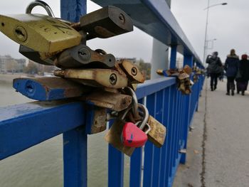 Close-up of padlocks on railing against bridge