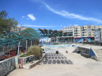 View of swimming pool by buildings against sky