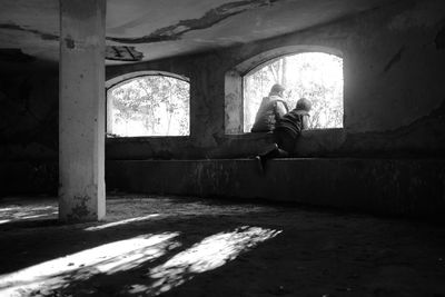 Man sitting on abandoned window