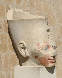 Close-up of old statue against wall