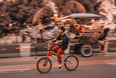 People riding bicycle on road in city