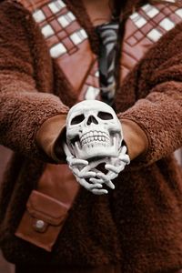 Midsection of person holding human skull