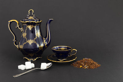 Close-up of tea cup on table against black background