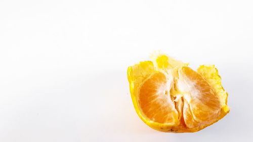 Close-up of orange fruit against white background