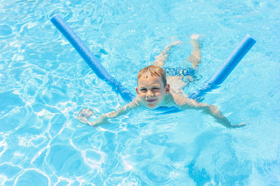 Portrait of smiling boy swimming in pool