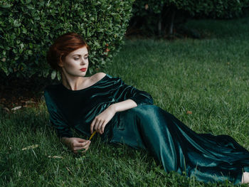 Young woman sitting on grassy field