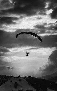 Low angle view of person paragliding against sky