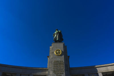 Low angle view of soviet war memorial against clear blue sky on sunny day