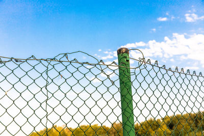 Low angle view of chainlink fence against sky