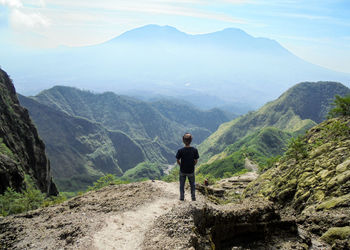 Rear view of man standing on mountain