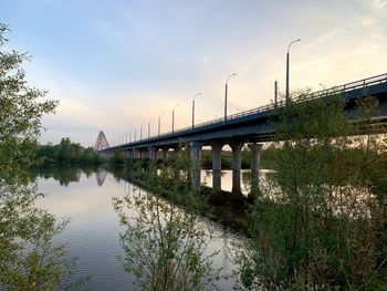 Bridge over river against sky during sunset