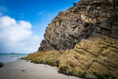 Rock formation on beach against sky