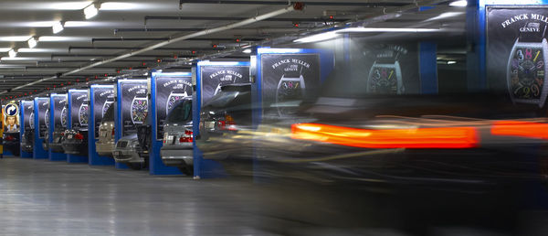 Blurred image of car moving in illuminated parking lot