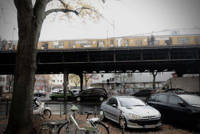 Cars on bridge in city against sky