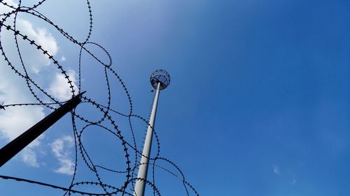 Low angle view of barbed wire against blue sky