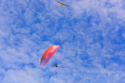 Low angle view of paragliding against sky