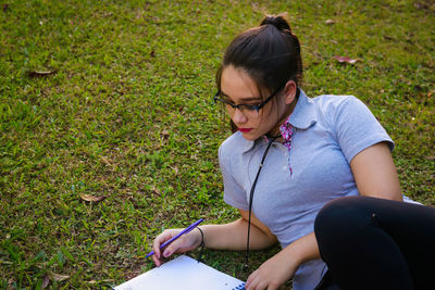 High angle view of young woman studying at park