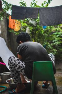Rear view of man sitting on chair at table