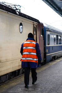 Rear view of man walking on railroad station