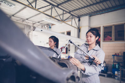 Woman repairing helicopter in workshop