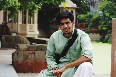 Portrait of young man sitting outdoors