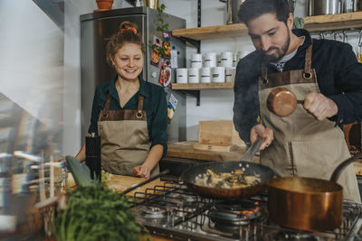 Happy man standing by food in kitchen