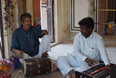 Musicians with instruments sitting on carpet 