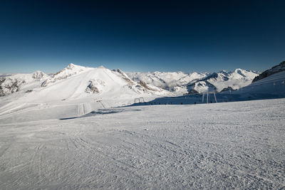 Scenic view of snowcapped mountains against clear blue sky