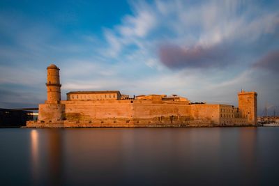 Historic building by river against sky