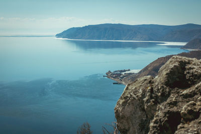 Scenic view of sea and mountains against clear blue sky