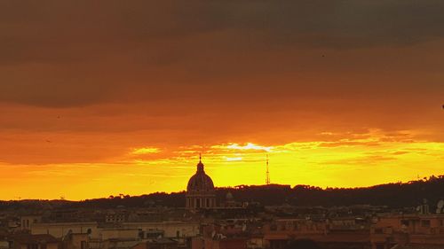 Silhouette buildings against sky during sunset