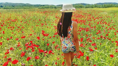 Rear view of woman standing in field