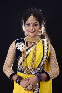 Portrait of smiling woman against black background