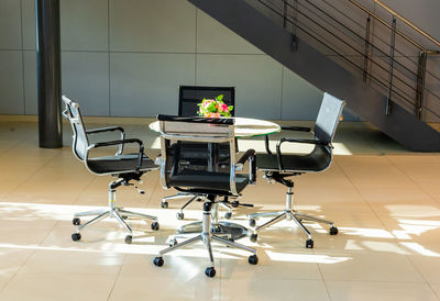 High angle view of chair and table with flower pot in lobby