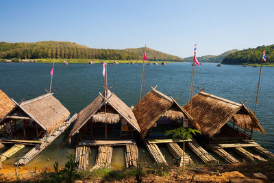 Panoramic view of cottage by lake against sky