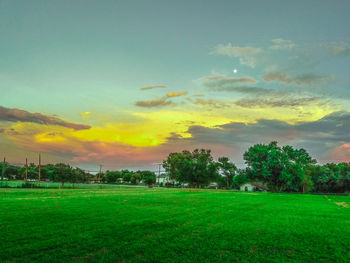 Scenic view of grassy field against cloudy sky