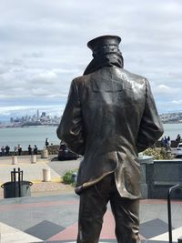 Statue by sea against sky in city