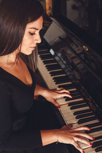 Midsection of woman playing piano